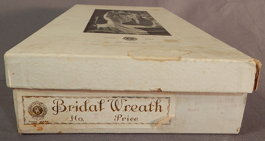 Vintage French Flapper Wax Flower Bridal Wreath Wedding Headband Headpiece & Box
The box measures 11 1/2 by 6 1/2 inches and is in good as-is condition, with some faint water spot stains and wear.