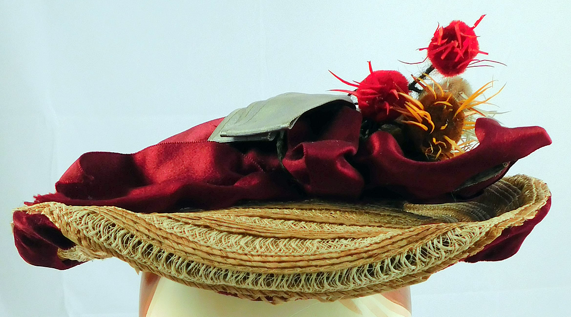 Victorian Womens Natural Straw Pork Pie Wide Brim Bonnet Hat Ribbon Thistle Trim
This charming ladies travel hat has a pork pie bonnet style with a low flat round shape, brim slightly upturned on the back with blue bow trim underneath and burgundy velvet edging, an attached chin strap and is unlined.