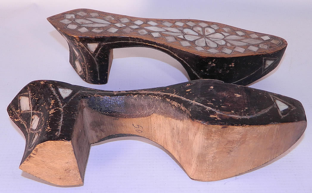 Antique Middle Eastern Mother of Pearl Inlaid Hand Carved Wooden Shoes. They are in good as found condition, with some wear, small chips to the wood black paint and is missing a piece of MOP inlay, as well as the upper strap across the foot. 