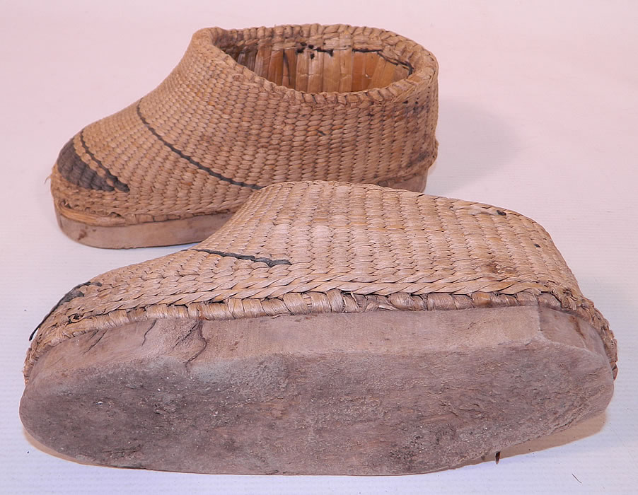 Antique Chinese Woven Braided Straw Hand Carved Wooden Farmers Shoes. The shoes measure 9 inches long and 3 inches wide. They are in good as found worn condition, with some wear to the straw and a chip along the edge of the wooden bottom sole.These are truly a one of a kind piece of wearable antique Chinese shoe art!