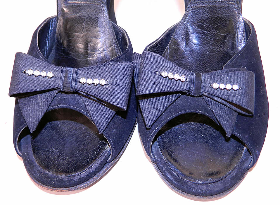 Vintage Black Suede Leather Rhinestone Bow Springolator Wedge Heel Mules Shoes. The shoes measure 9 1/2 inches long, 3 inches wide, with 4 inch high heels and are approximately a size 6 or 7. 