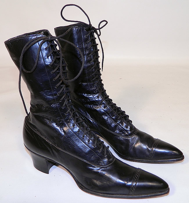 Vintage Poehlman Shoe Co Unworn Victorian Black Leather High Top Lace-up Boots. The boots have pointed toes, the original black shoe string laces for closure and black stacked wooden cube heels. 