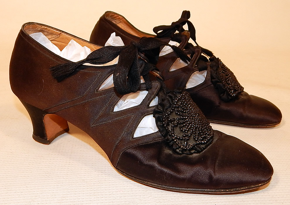 Vintage Thayer McNeil Co Boston Black Silk Beaded Buckle Eyelet Flapper Shoes
They are made of a black silk satin fabric with black beaded buckle trim on the front instep vamps. 