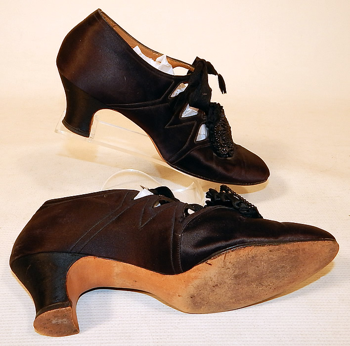 Vintage Thayer McNeil Co Boston Black Silk Beaded Buckle Eyelet Flapper Shoes
These fabulous flapper shoes have decorative eyelet cut out openings along the sides with lacing closures and silk covered cube heels. 