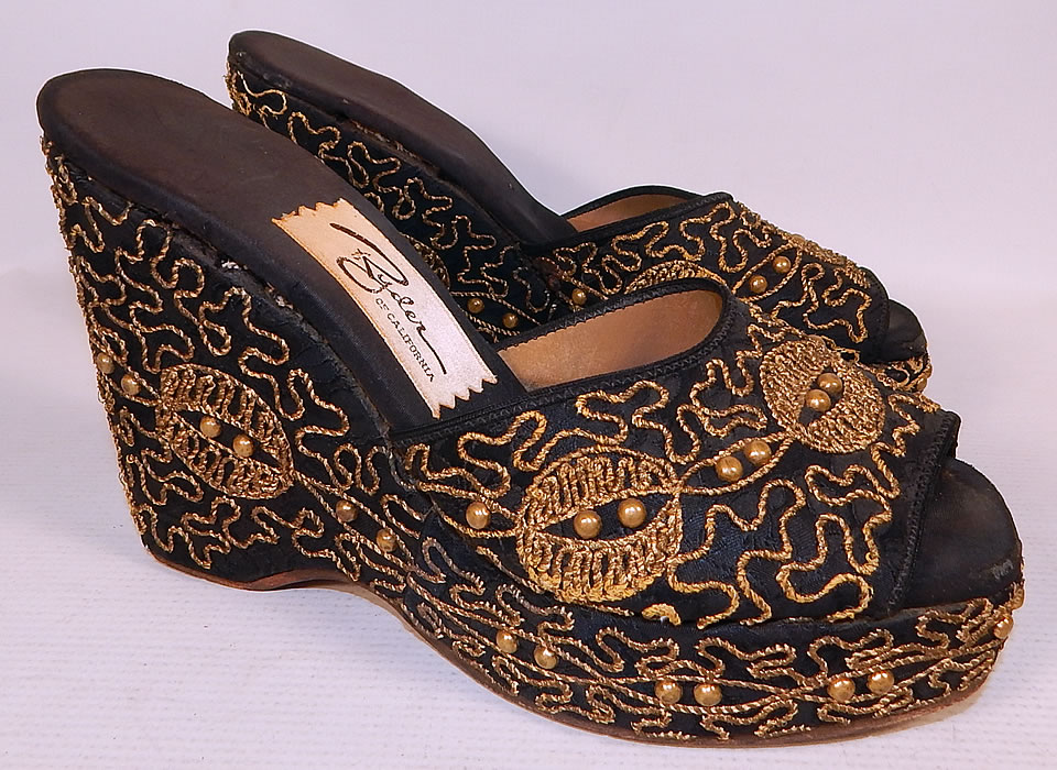 Vintage Ryder of California Black Gold Studded Soutache Wedge Heel Platform Shoes
This pair of vintage Ryder of California black gold studded soutache wedge heel platform shoes date from the 1940s. They are made of a black silk satin fabric, with gold soutache rope raised embroidery work and brass studded trim.