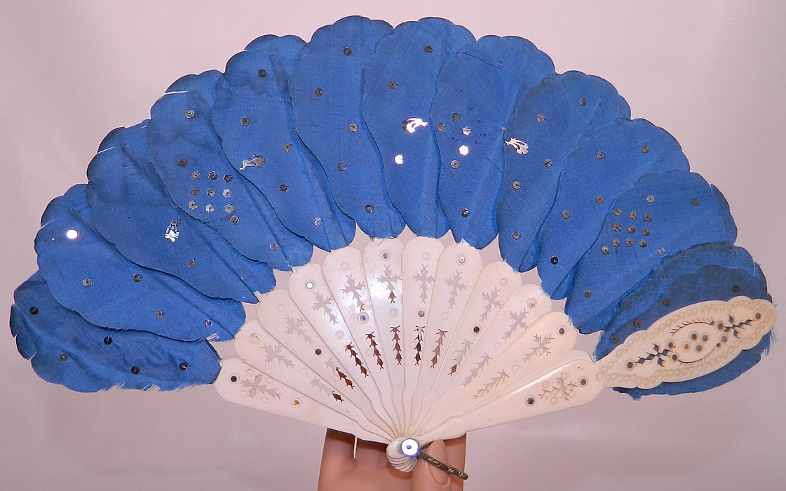 Victorian Blue Silk Feather Silver Sequin Carved Pierced Jenny Lind Fan. This antique Victorian era blue silk feather silver sequin carved pierced sticks Jenny Lind fan dates from the 1850s. It is made of a scalloped petal blue silk fabric cut and shaped like a feather, with hand sewn tiny silver sequins on the front mounted on sticks.