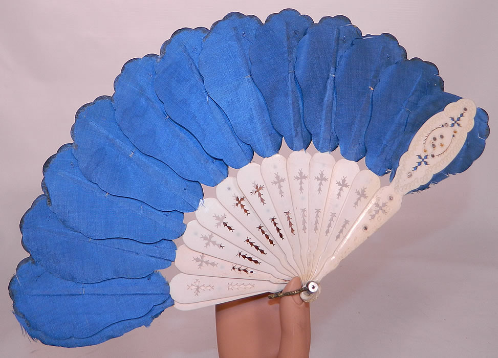 Victorian Blue Silk Feather Silver Sequin Carved Pierced Jenny Lind Fan. There are carved and pierced bone sticks and guards, with silver inlays and a brass loop, mother of pearl rivet attached onto the bottom holding the fan together. This pretty petite fan became fashionable during the popularity of the famous vocalist Jenny Lind and might have been used by a lady for a ball dance or wedding.