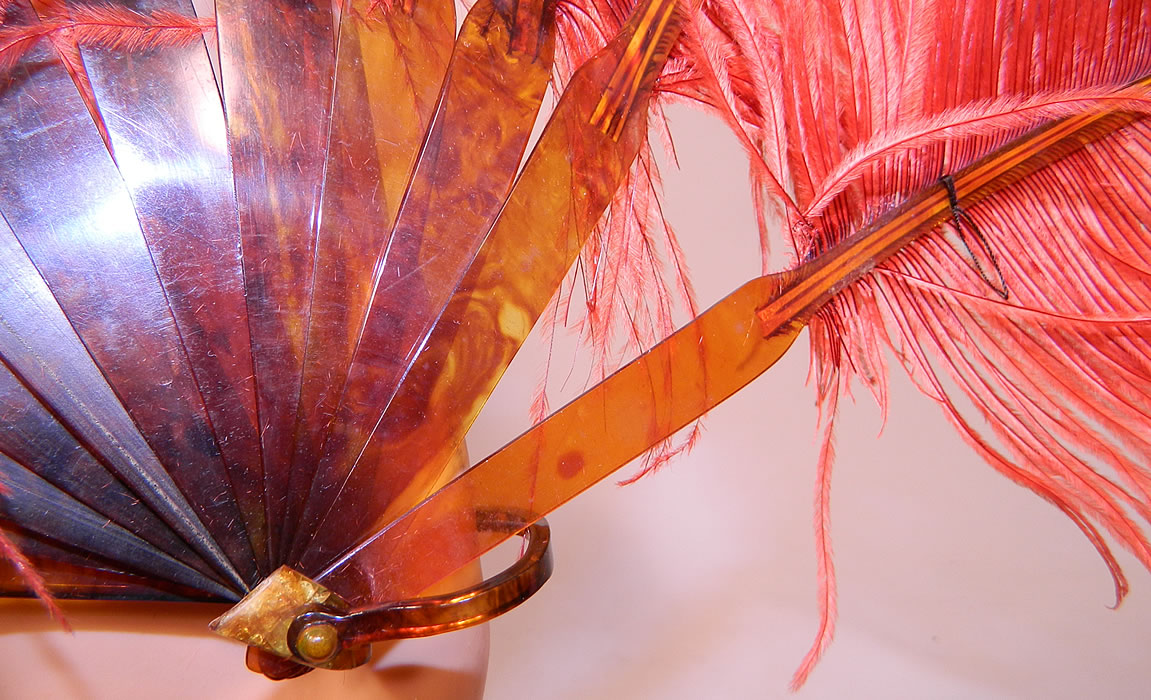 Vintage Art Deco Red & Pink Ostrich Feather Folding Fixed Flapper Fans
It measures 24 inches long and 10 inches wide. The other fan is made of a dyed reddish orange color fluffy ostrich feather plumes. This fabulous flapper folding fan has faux tortoise shell celluloid sticks, guards and loop rivet on the bottom. 