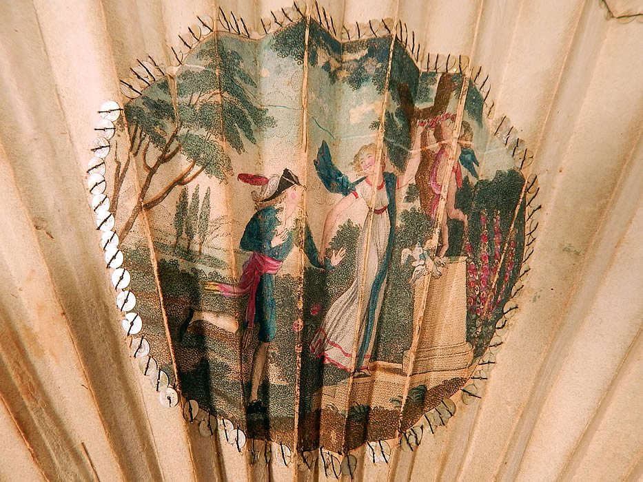 Antique 18th Century Hand Painted Paper Sequin Pierced Carved Folding Fan & Box
There is a beautiful vignette of a romantic couple in love with cupid, white doves and garland of flowers on a pedestal. 